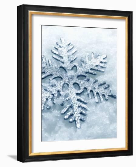 Snowflake Shaped Christmas Ornament Lying in the Snow-null-Framed Photographic Print