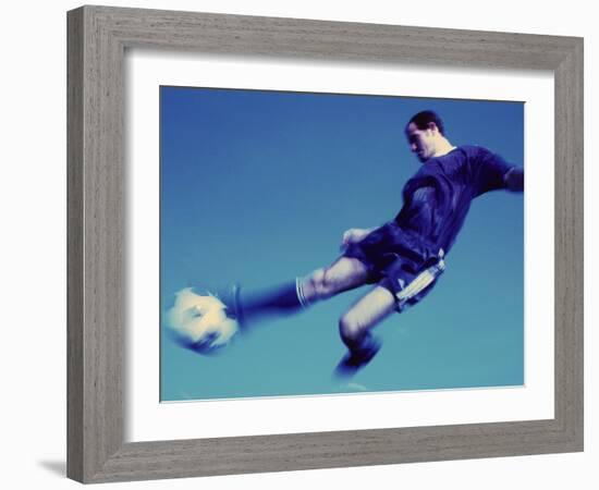 Soccer Player Jumping in Mid Air to Kick a Soccer Ball-null-Framed Photographic Print