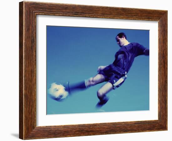 Soccer Player Jumping in Mid Air to Kick a Soccer Ball-null-Framed Photographic Print