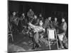 Songwriter Irving Berlin Reading Newspaper as Others Sit around Talking-null-Mounted Photographic Print