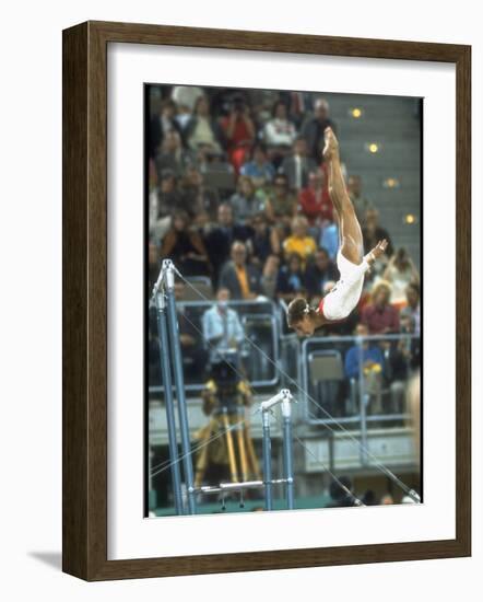 Soviet Gymnast Olga Korbut in Action on the Uneven Bars at the Summer Olympics-John Dominis-Framed Premium Photographic Print