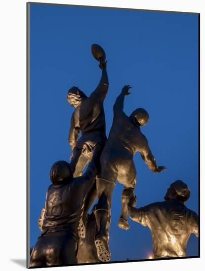 Statue of rugby players is illuminated at dusk outside Twickenham Stadium, London-Charles Bowman-Mounted Photographic Print