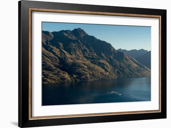 Steamship powers across a dark lake with sharp large mountains, Queenstown, Otago, New Zealand-Logan Brown-Framed Photographic Print