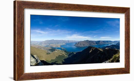 Steep sharp mountains, a deep blue lake, and mountain town in Queenstown, Otago, New Zealand-Logan Brown-Framed Photographic Print