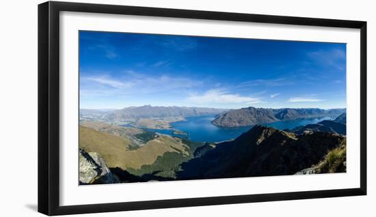 Steep sharp mountains, a deep blue lake, and mountain town in Queenstown, Otago, New Zealand-Logan Brown-Framed Photographic Print