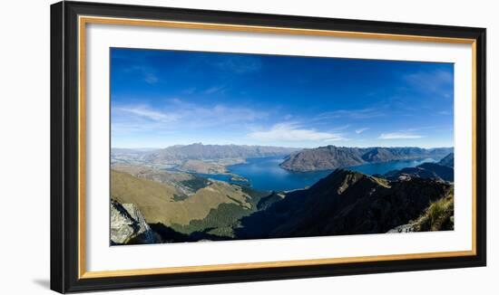 Steep sharp mountains, a deep blue lake, and mountain town in Queenstown, Otago, New Zealand-Logan Brown-Framed Photographic Print