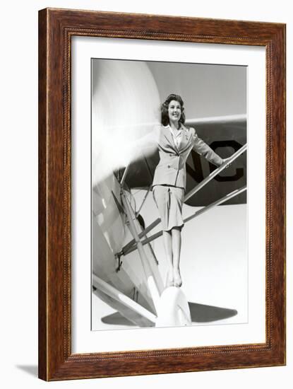 Stewardess Balancing on Plane Wheel-null-Framed Art Print