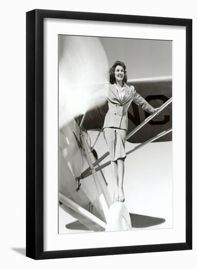 Stewardess Balancing on Plane Wheel-null-Framed Art Print