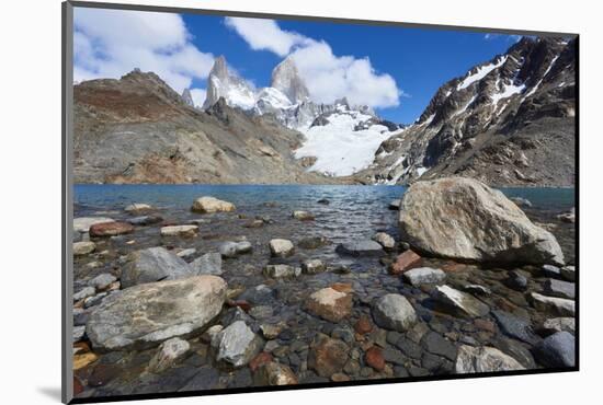 Stones seen through the water of Lago de los Tres featuring Monte Fitz Roy in the background. Monte-Fernando Carniel Machado-Mounted Photographic Print