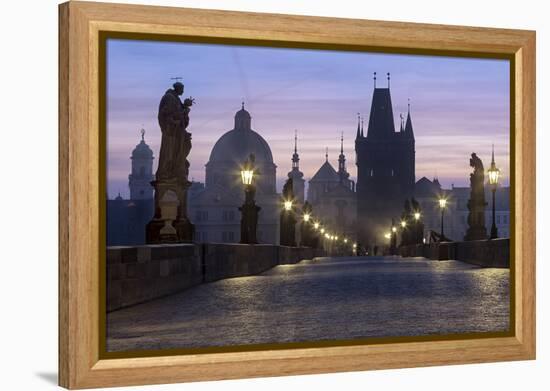 Street lanterns and old statues frame the historical buildings on Charles Bridge at dawn, UNESCO Wo-Roberto Moiola-Framed Premier Image Canvas