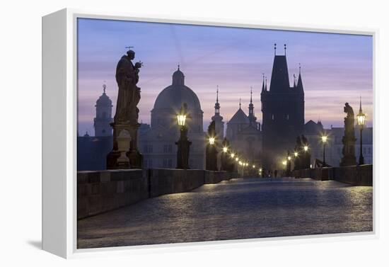 Street lanterns and old statues frame the historical buildings on Charles Bridge at dawn, UNESCO Wo-Roberto Moiola-Framed Premier Image Canvas