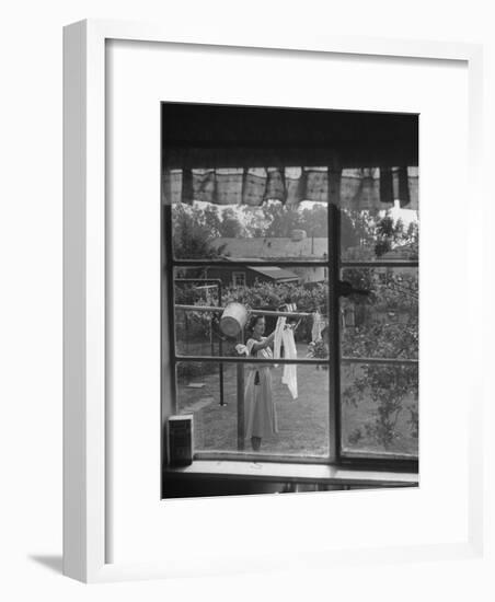 Suburban Housewife Hanging Out a Bit of Laundry, Seen Through Window in typical California Home-Loomis Dean-Framed Photographic Print