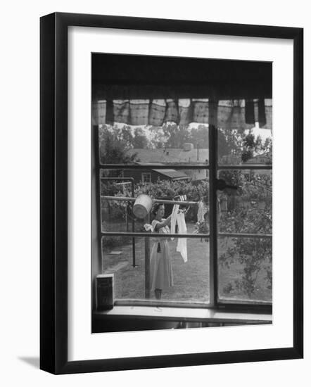 Suburban Housewife Hanging Out a Bit of Laundry, Seen Through Window in typical California Home-Loomis Dean-Framed Photographic Print