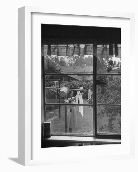 Suburban Housewife Hanging Out a Bit of Laundry, Seen Through Window in typical California Home-Loomis Dean-Framed Photographic Print