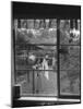 Suburban Housewife Hanging Out a Bit of Laundry, Seen Through Window in typical California Home-Loomis Dean-Mounted Photographic Print