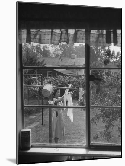 Suburban Housewife Hanging Out a Bit of Laundry, Seen Through Window in typical California Home-Loomis Dean-Mounted Photographic Print