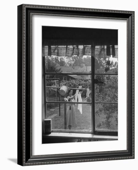 Suburban Housewife Hanging Out a Bit of Laundry, Seen Through Window in typical California Home-Loomis Dean-Framed Photographic Print