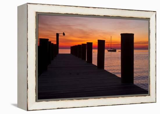 Sunrise on the Water with an Empty Dock and a Sailboat in the Distance of Tilghman Island, Maryland-Karine Aigner-Framed Premier Image Canvas