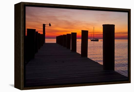 Sunrise on the Water with an Empty Dock and a Sailboat in the Distance of Tilghman Island, Maryland-Karine Aigner-Framed Premier Image Canvas