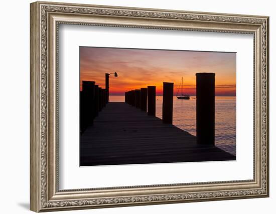 Sunrise on the Water with an Empty Dock and a Sailboat in the Distance of Tilghman Island, Maryland-Karine Aigner-Framed Photographic Print