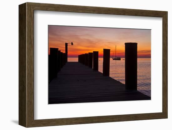 Sunrise on the Water with an Empty Dock and a Sailboat in the Distance of Tilghman Island, Maryland-Karine Aigner-Framed Photographic Print