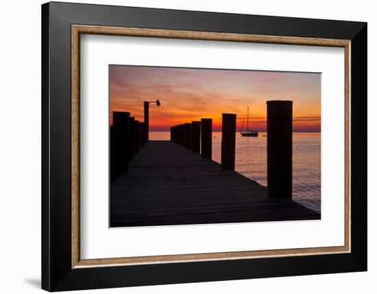 Sunrise on the Water with an Empty Dock and a Sailboat in the Distance of Tilghman Island, Maryland-Karine Aigner-Framed Photographic Print