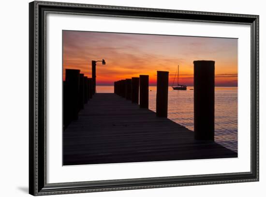 Sunrise on the Water with an Empty Dock and a Sailboat in the Distance of Tilghman Island, Maryland-Karine Aigner-Framed Photographic Print