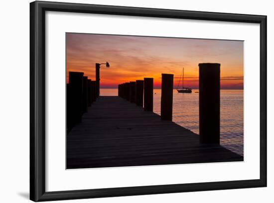 Sunrise on the Water with an Empty Dock and a Sailboat in the Distance of Tilghman Island, Maryland-Karine Aigner-Framed Photographic Print