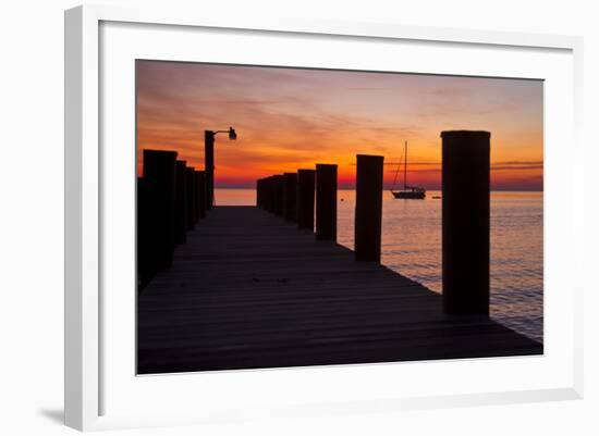 Sunrise on the Water with an Empty Dock and a Sailboat in the Distance of Tilghman Island, Maryland-Karine Aigner-Framed Photographic Print