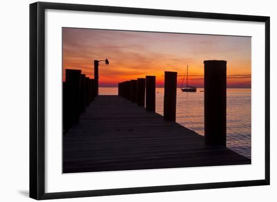 Sunrise on the Water with an Empty Dock and a Sailboat in the Distance of Tilghman Island, Maryland-Karine Aigner-Framed Photographic Print