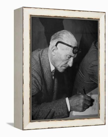 Swiss Architect Le Corbusier Leaning Down to Write with His Glasses Pushed Back on His Forehead-null-Framed Premier Image Canvas