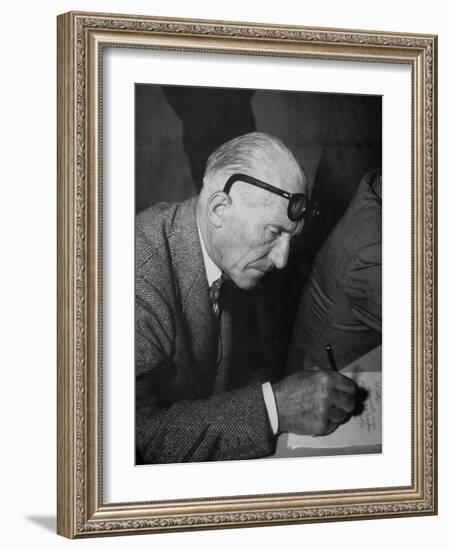 Swiss Architect Le Corbusier Leaning Down to Write with His Glasses Pushed Back on His Forehead-null-Framed Photographic Print