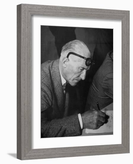 Swiss Architect Le Corbusier Leaning Down to Write with His Glasses Pushed Back on His Forehead-null-Framed Photographic Print