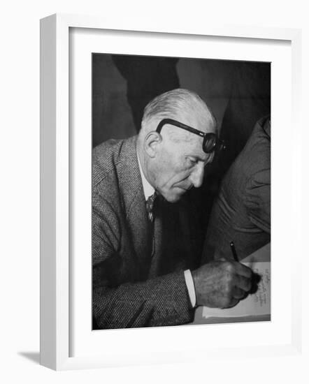 Swiss Architect Le Corbusier Leaning Down to Write with His Glasses Pushed Back on His Forehead-null-Framed Photographic Print