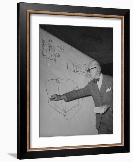 Swiss Architect Le Corbusier Standing on Stage with Notes in His Hand and Drawing on Sketch Pad-null-Framed Photographic Print