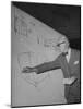 Swiss Architect Le Corbusier Standing on Stage with Notes in His Hand and Drawing on Sketch Pad-null-Mounted Photographic Print