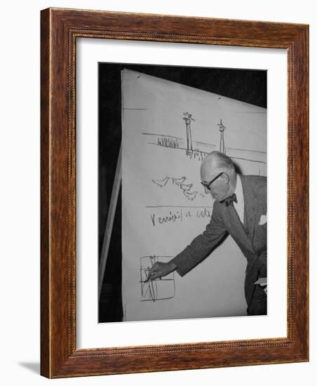 Swiss Architect Le Corbusier Standing on Stage with Notes in His Hand and Drawing on Sketch Pad-null-Framed Photographic Print