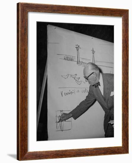 Swiss Architect Le Corbusier Standing on Stage with Notes in His Hand and Drawing on Sketch Pad-null-Framed Photographic Print