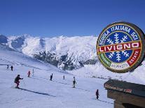 Sign with Skiers and Mountains in the Background at the Ski Resort of Livigno in Northern Italy-Teegan Tom-Photographic Print