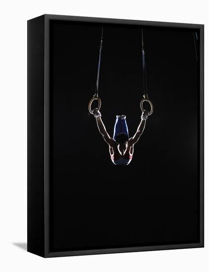 Teenage (16-17) Male Gymnast Practicing on Rings against Black Background-Thomas Barwick-Framed Premier Image Canvas