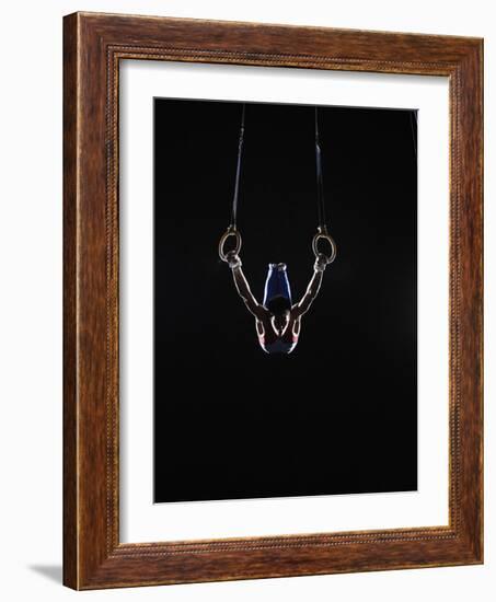 Teenage (16-17) Male Gymnast Practicing on Rings against Black Background-Thomas Barwick-Framed Photographic Print