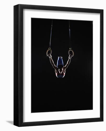 Teenage (16-17) Male Gymnast Practicing on Rings against Black Background-Thomas Barwick-Framed Photographic Print