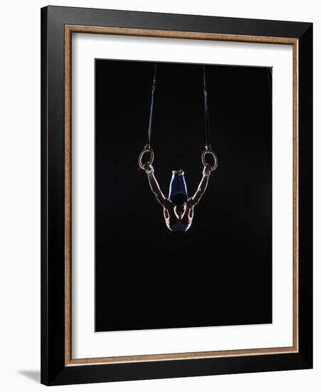 Teenage (16-17) Male Gymnast Practicing on Rings against Black Background-Thomas Barwick-Framed Photographic Print