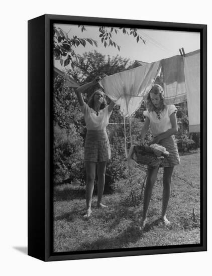 Teenage Twin Girls Hanging Laundry on Clothesline-Nina Leen-Framed Premier Image Canvas