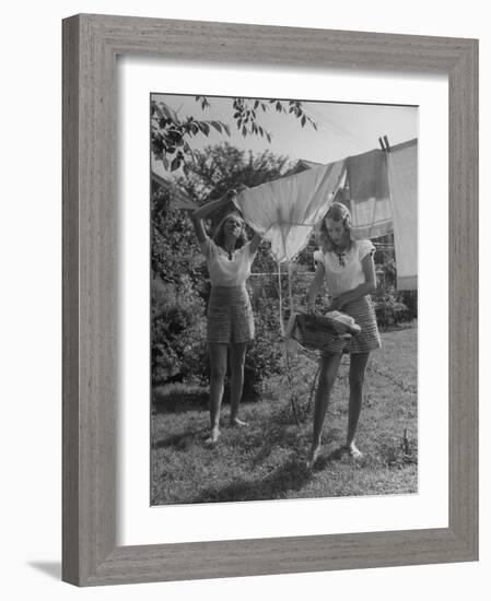 Teenage Twin Girls Hanging Laundry on Clothesline-Nina Leen-Framed Photographic Print