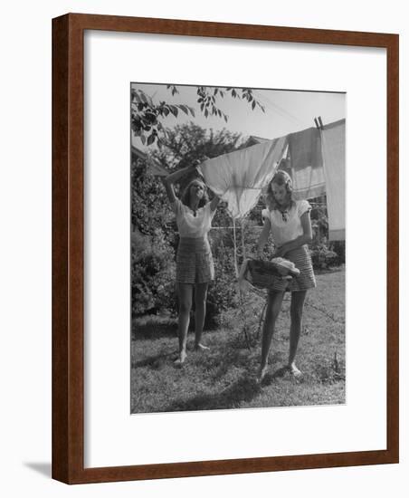 Teenage Twin Girls Hanging Laundry on Clothesline-Nina Leen-Framed Photographic Print