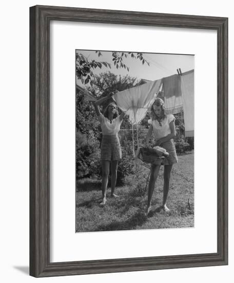 Teenage Twin Girls Hanging Laundry on Clothesline-Nina Leen-Framed Photographic Print