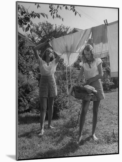 Teenage Twin Girls Hanging Laundry on Clothesline-Nina Leen-Mounted Photographic Print