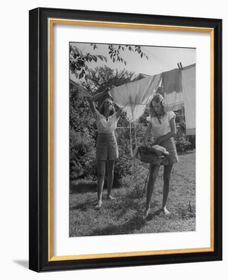 Teenage Twin Girls Hanging Laundry on Clothesline-Nina Leen-Framed Photographic Print