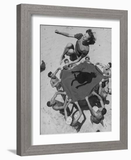 Teenaged Boys Using Blanket to Toss Their Friend, Norma Baker, Into the Air on the Beach-John Florea-Framed Photographic Print
